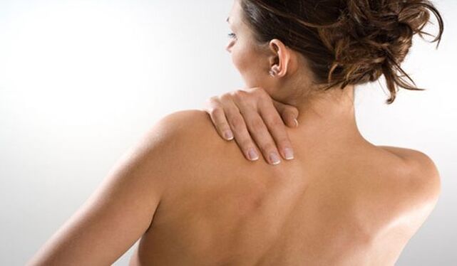 A mulher está preocupada com a dor sob a omoplata esquerda nas costas